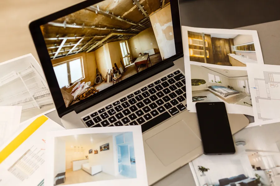Laptop with the design proposals and drawings on the table
